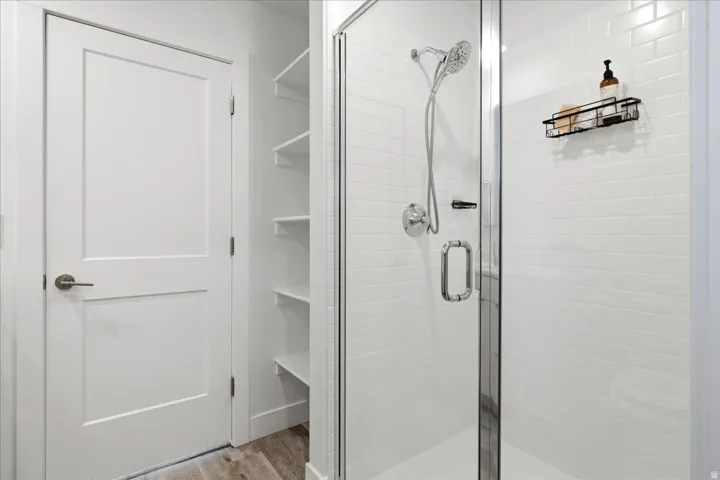 Primary bathroom featuring a walk-in shower, contemporary finishes, and a spacious layout.