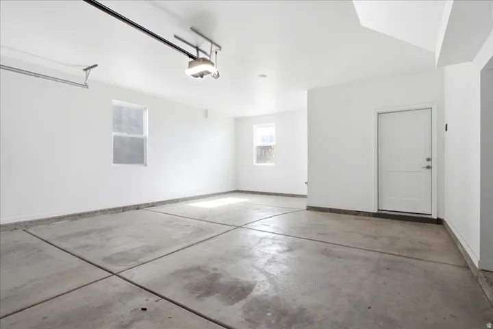 Oversized two-car garage featuring a 220V outlet, ideal for EV charging, workshop space, or additional storage.