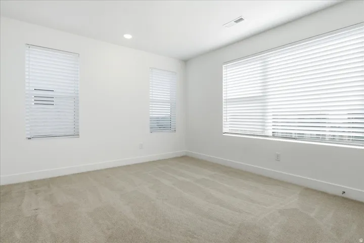 Bright secondary bedroom with expansive windows, mountain views, and generous natural light.