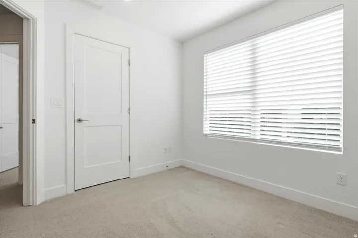 Bright secondary bedroom with expansive windows, mountain views, and generous natural light.
