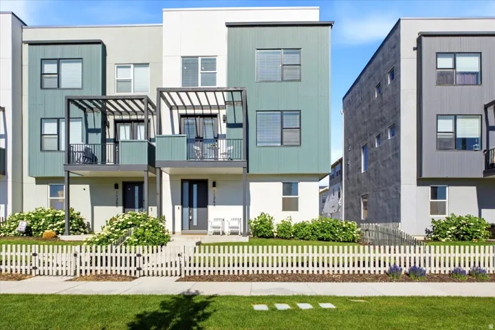 End-unit Daybreak townhome with a fenced front yard, covered entry, and contemporary architecture.