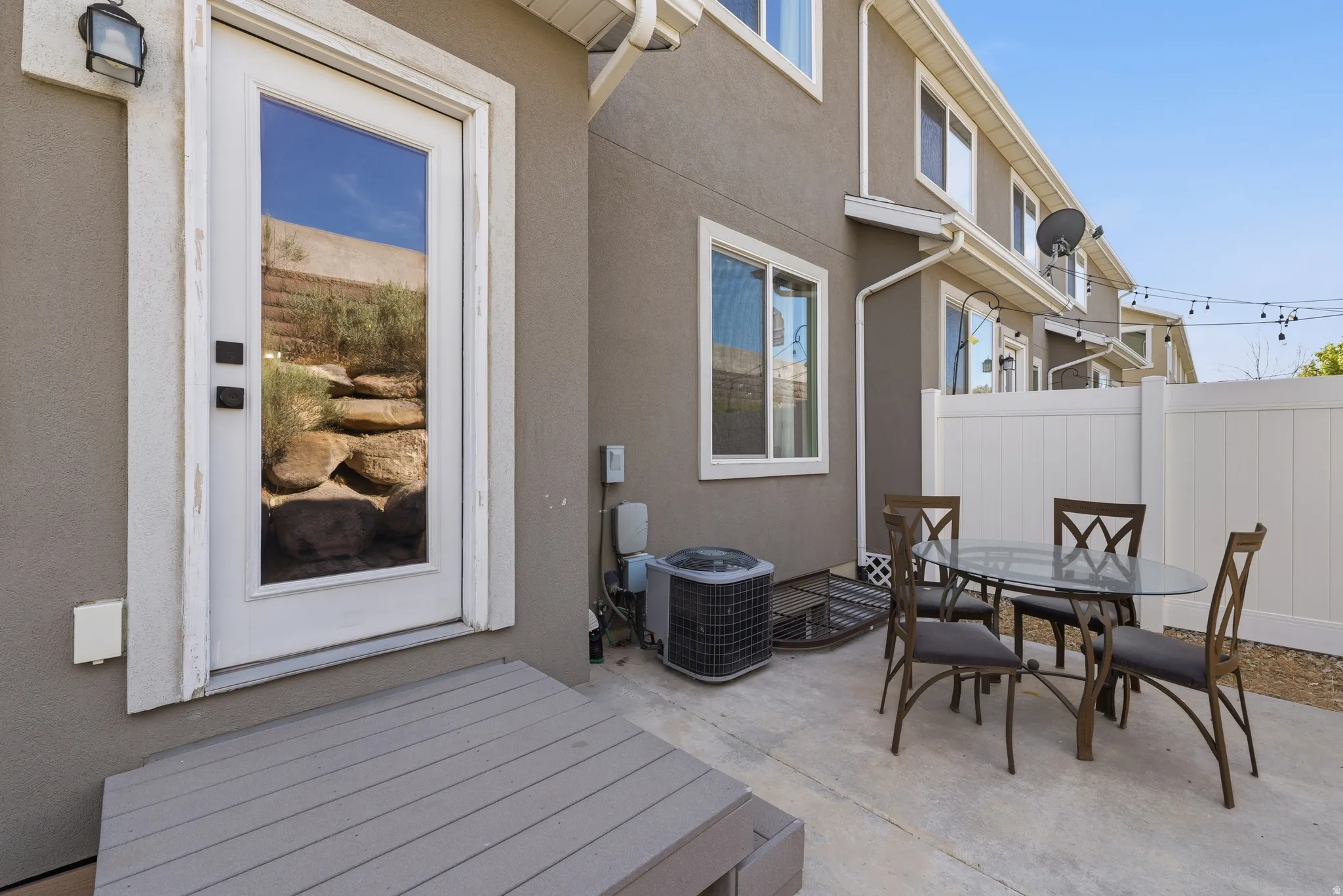 Private patio space featuring a concrete pad and white privacy fencing