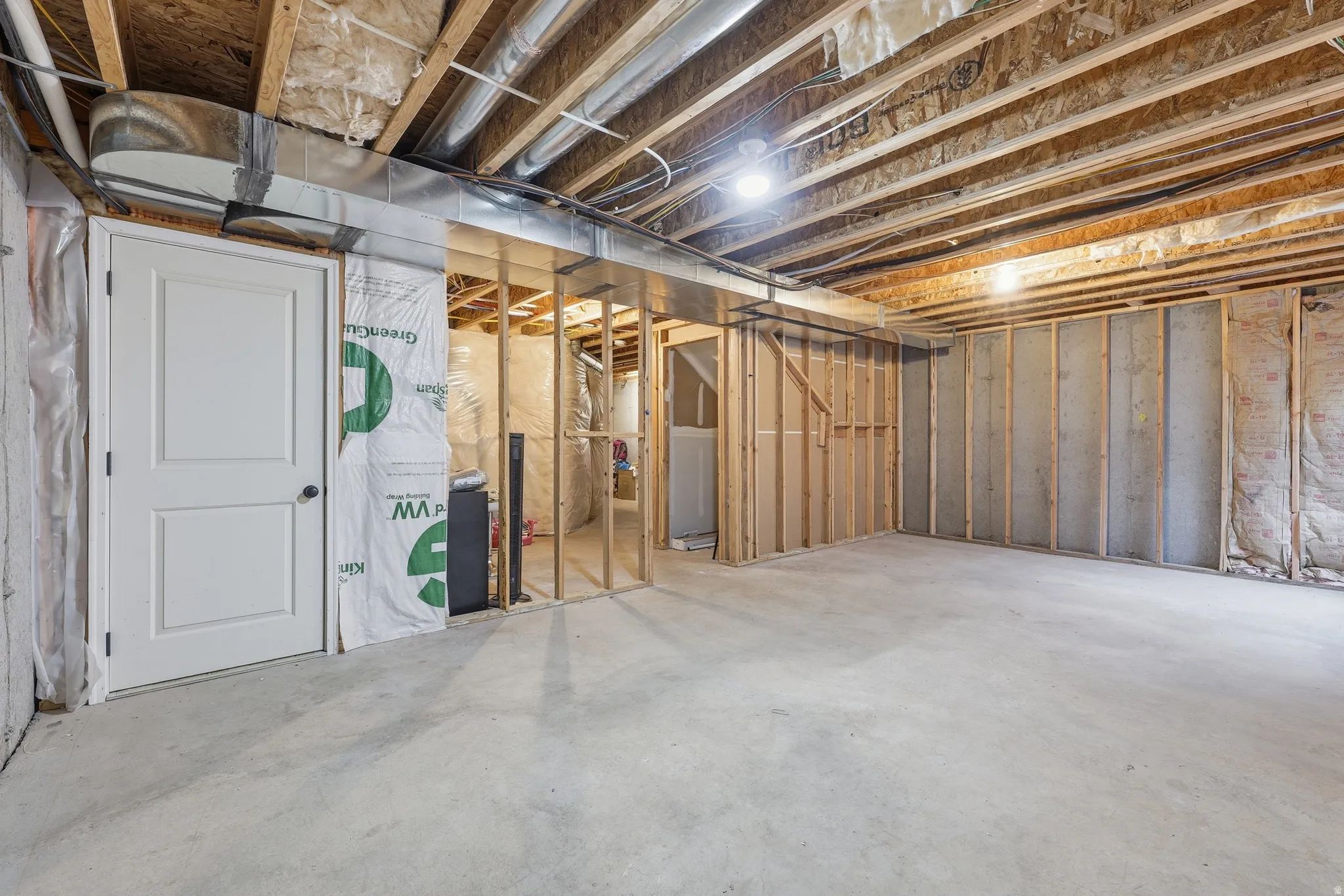 Unfinished basement offering expansive concrete flooring, exposed wood joists, and visible ductwork