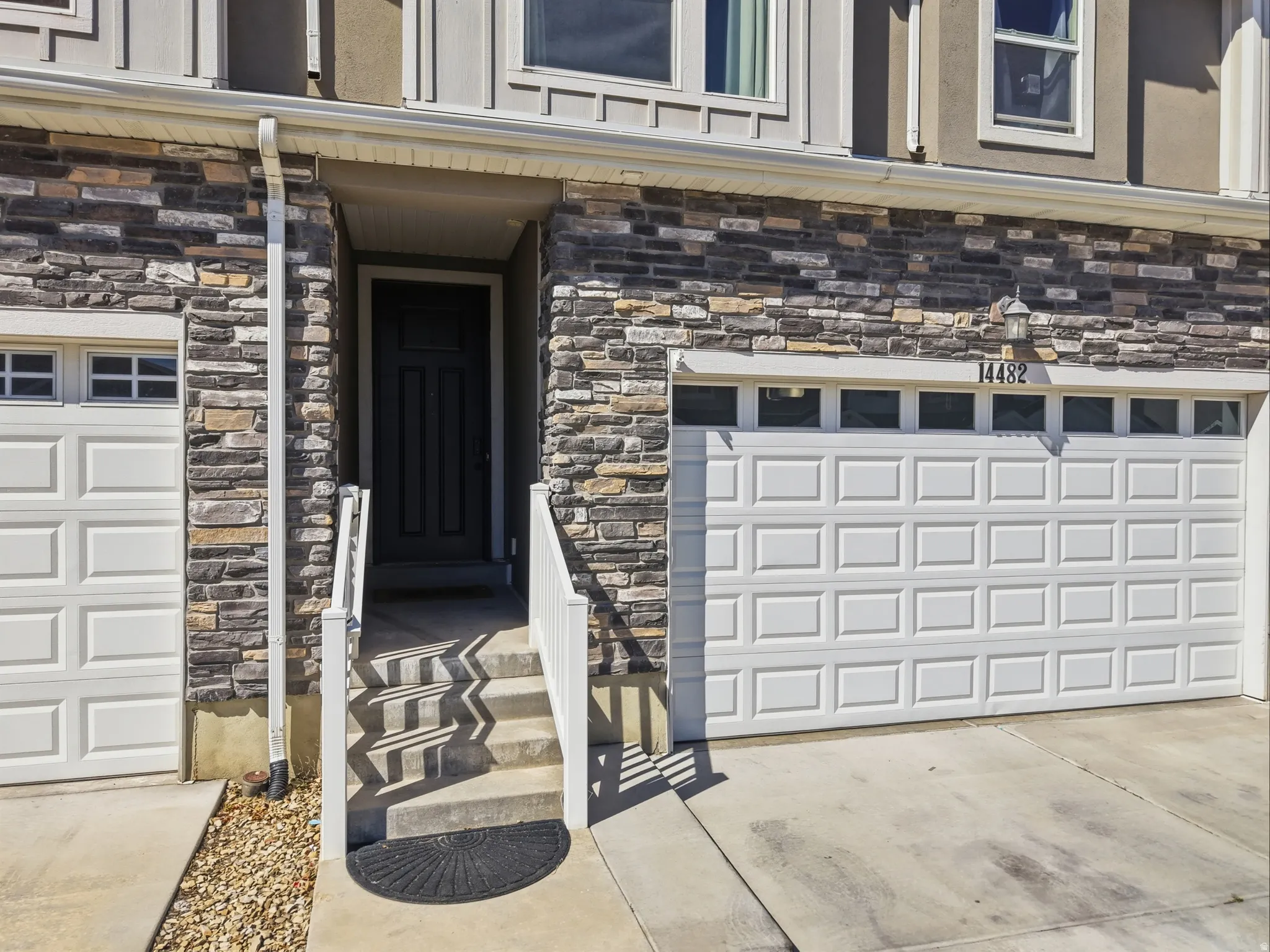 Stone veneer facade with a covered entry and concrete steps