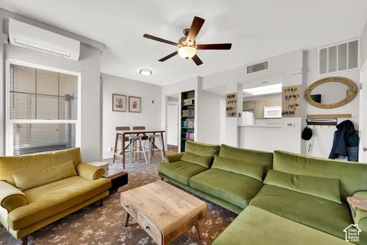 Open-concept living space featuring patterned carpeting and a ceiling fan