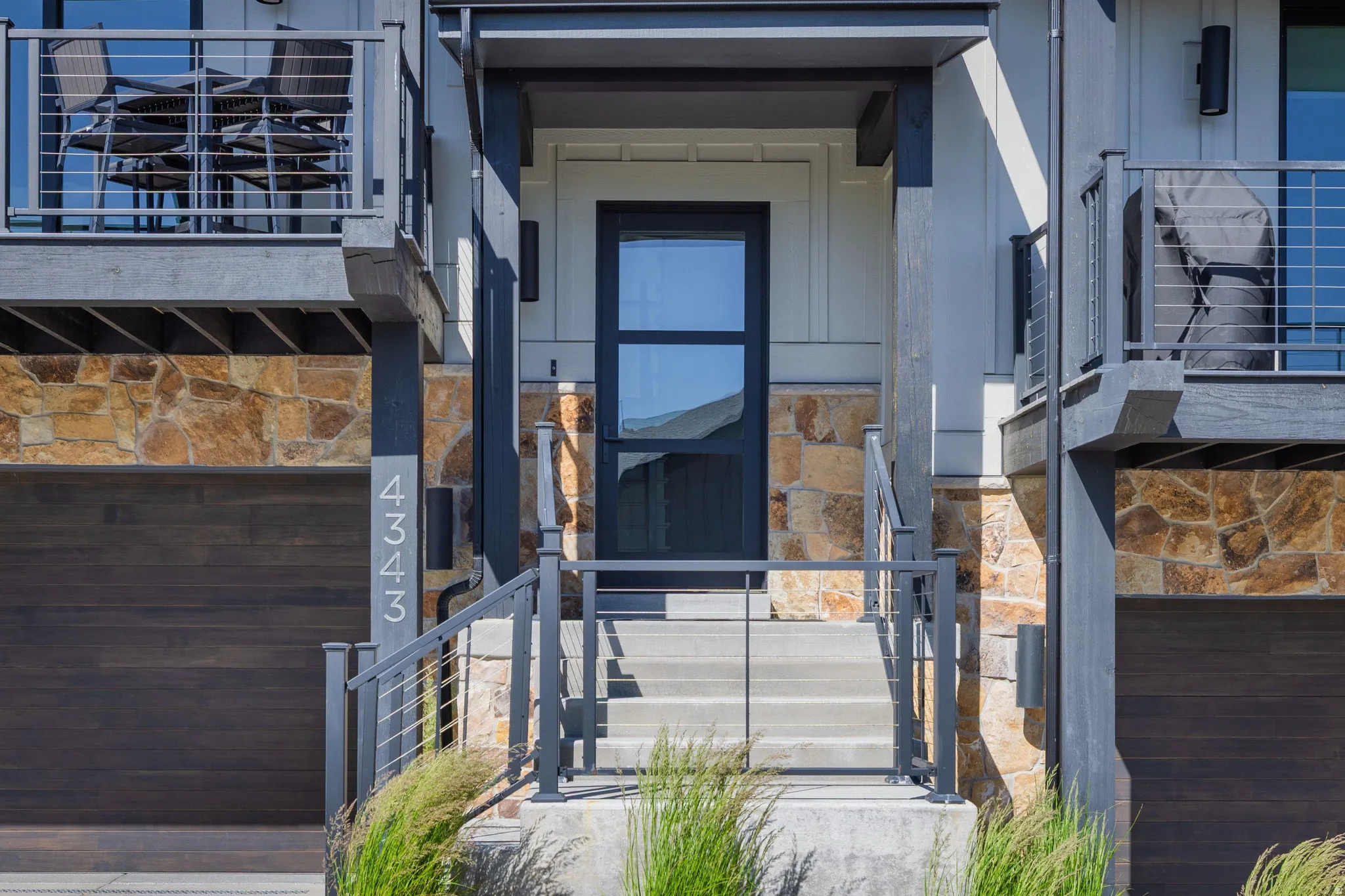 Contemporary facade featuring board and batten siding with natural stone accents