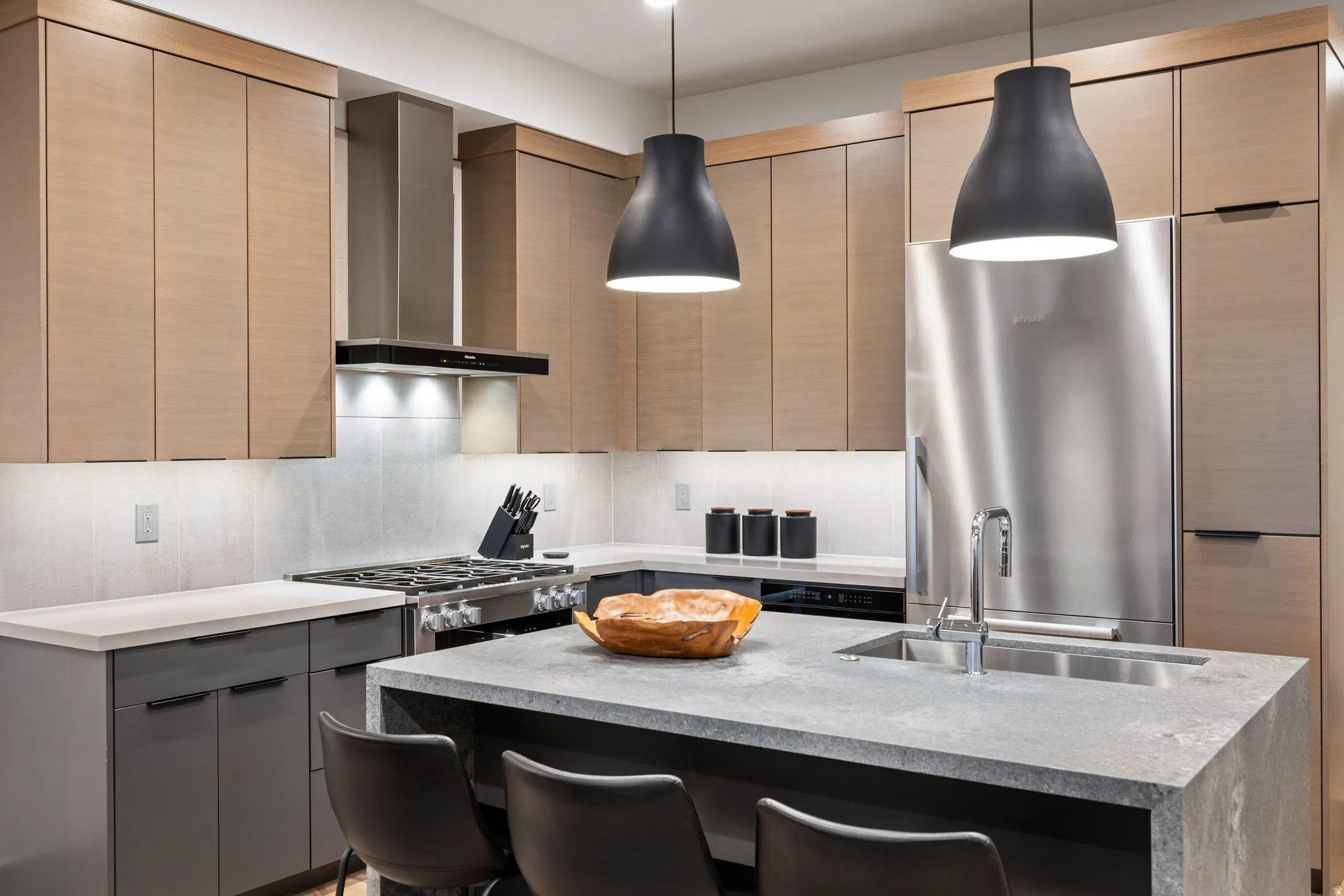 Contemporary kitchen featuring light wood-finish upper cabinetry and dark lower cabinetry