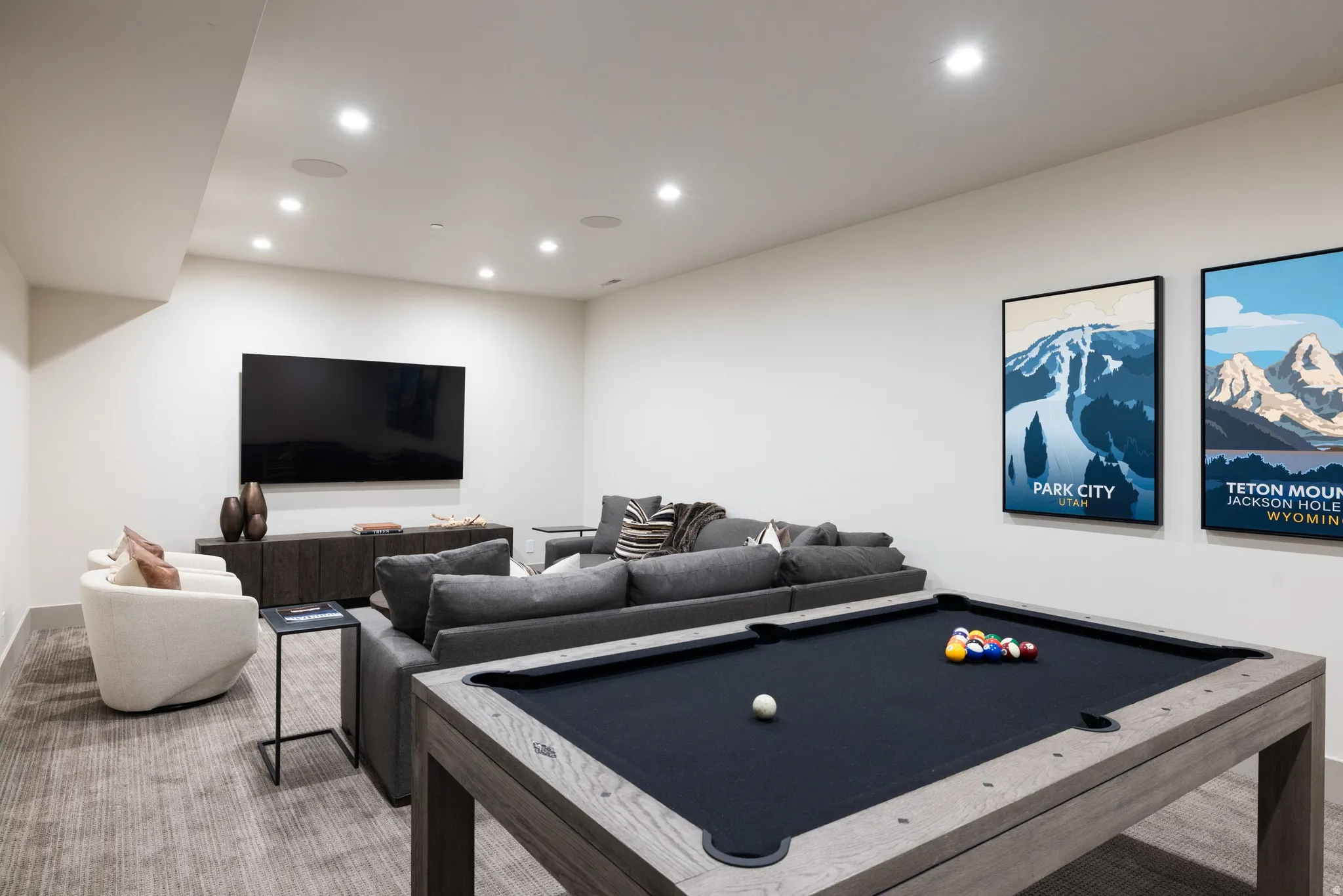 Spacious recreational room featuring a billiards table, recessed ceiling lighting, and a large wall-mounted entertainment display