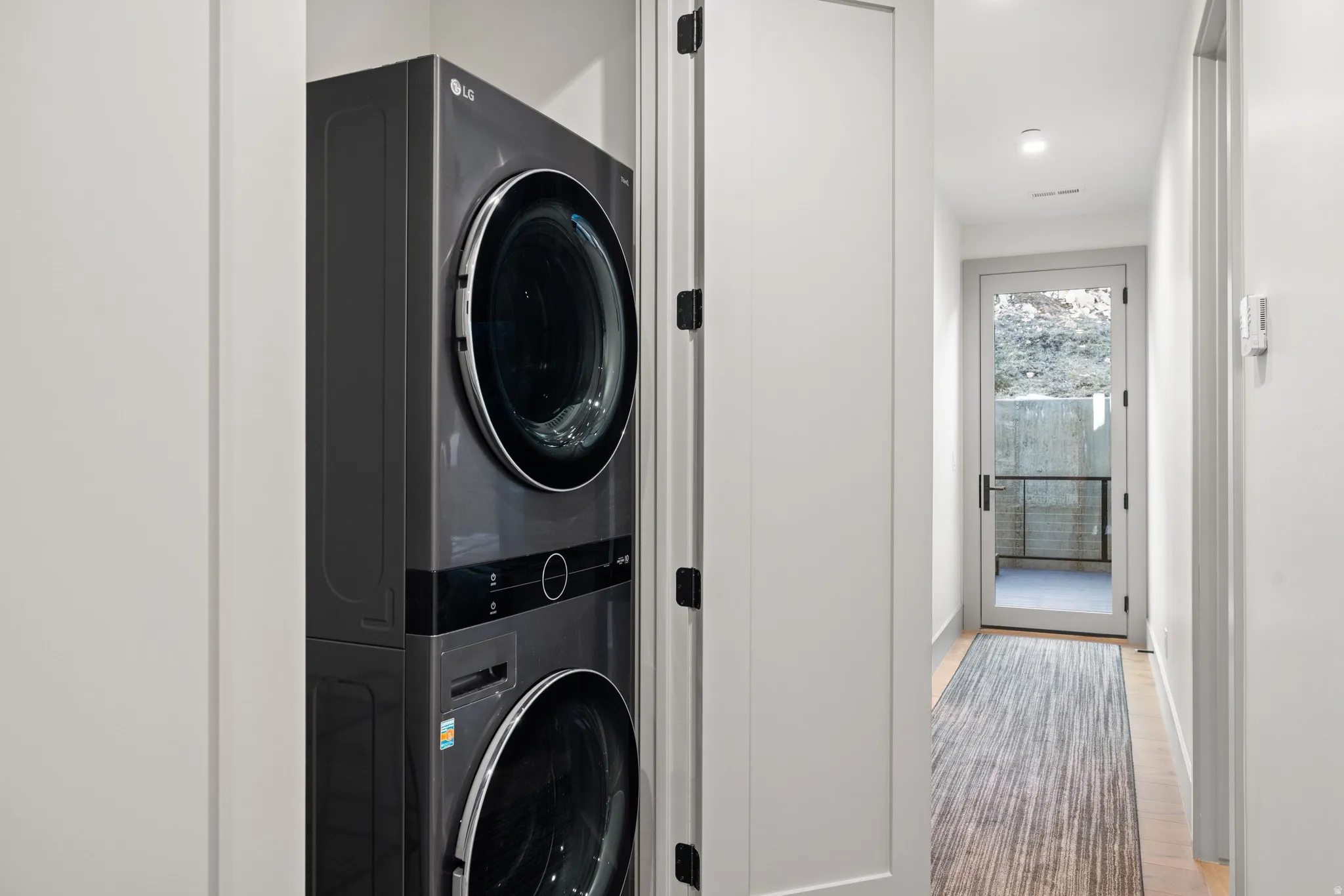 Dedicated laundry closet featuring a stacked washer and dryer unit