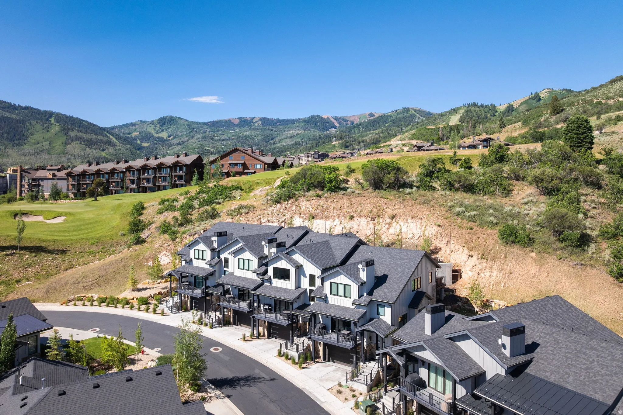 Contemporary multi-level residences featuring light-toned siding and dark-hued trim