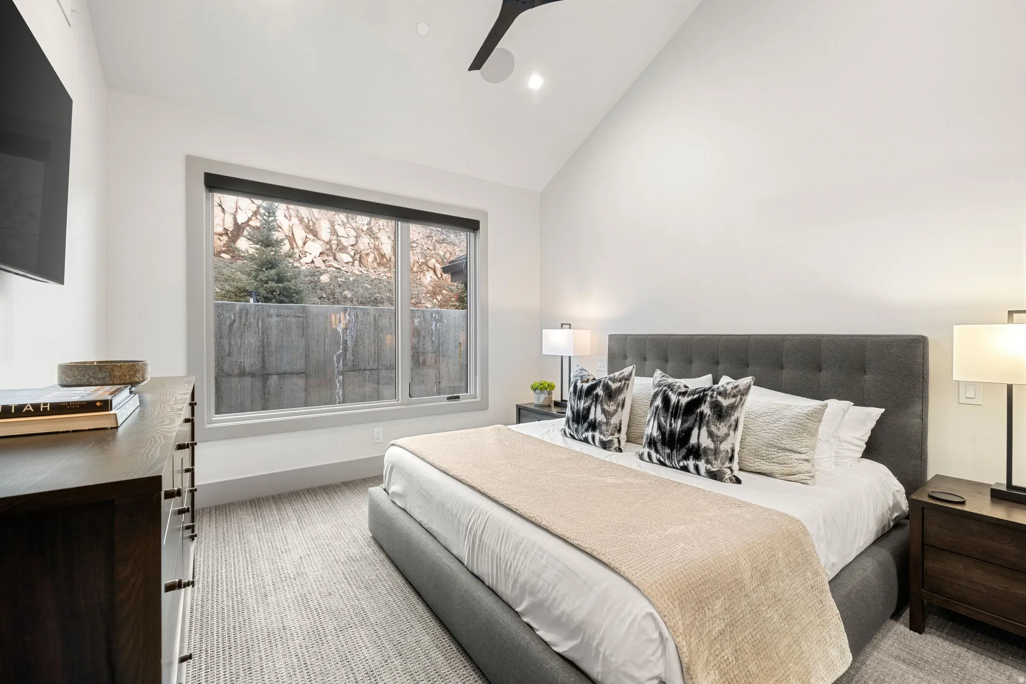 Vaulted ceiling bedroom with a large window, recessed lighting, and a contemporary ceiling fan