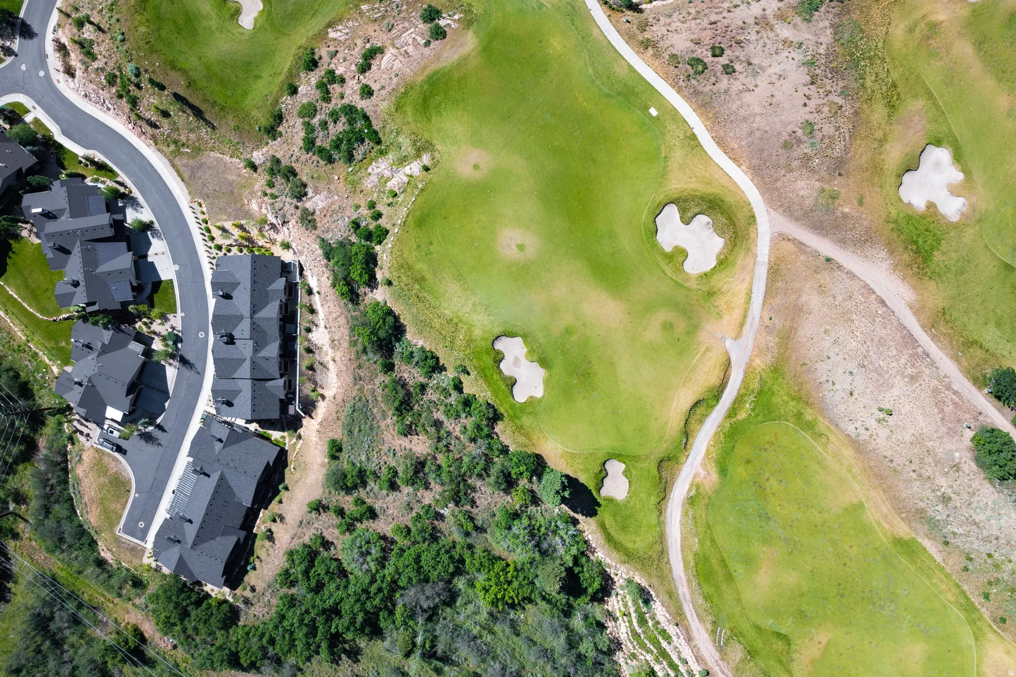 Aerial perspective showcasing residential properties bordering a golf course