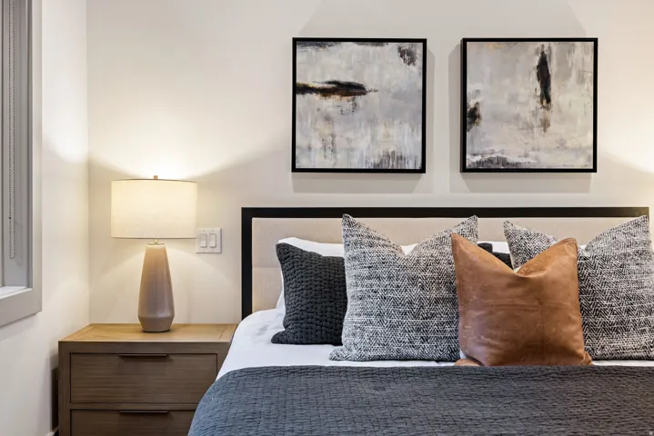 Bedroom featuring a paneled headboard, modern nightstand with drawer storage, and light-colored walls