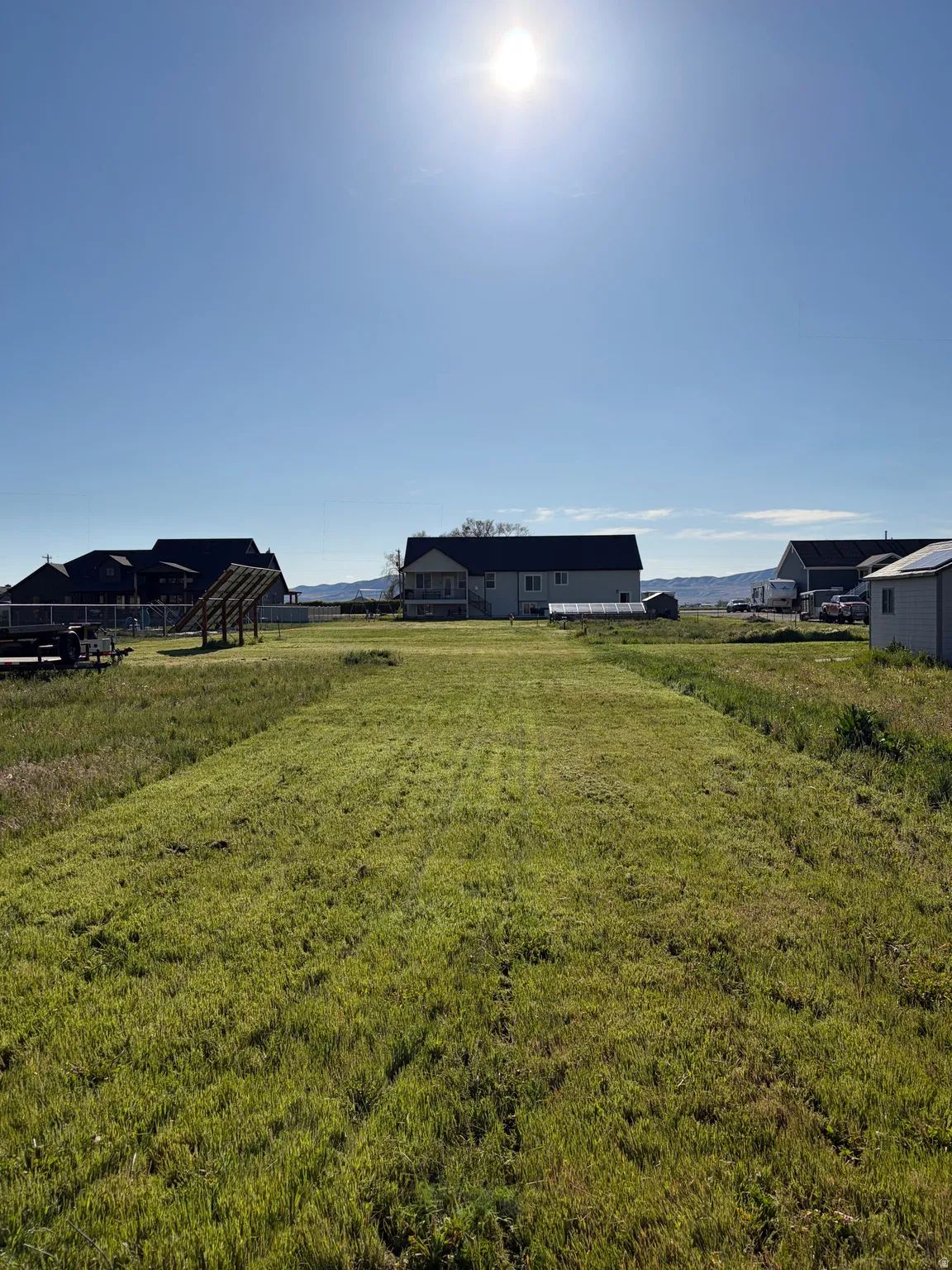 Expansive green space with clear skies and distant mountain ranges