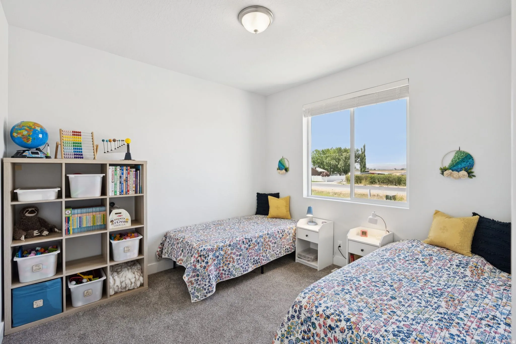 Bright room featuring a large window, neutral wall tones, and carpet flooring