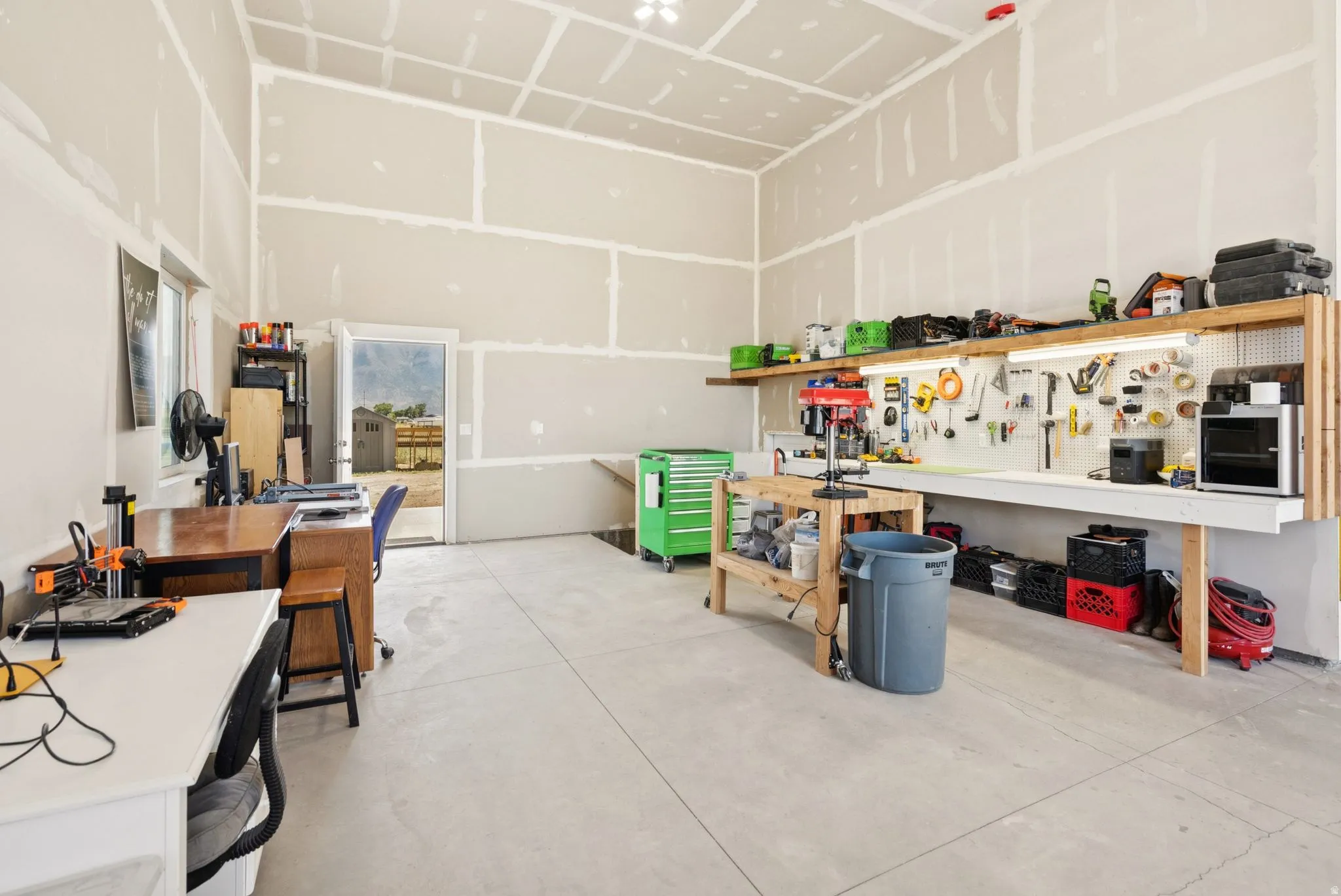 Spacious workshop featuring concrete flooring and exposed drywall