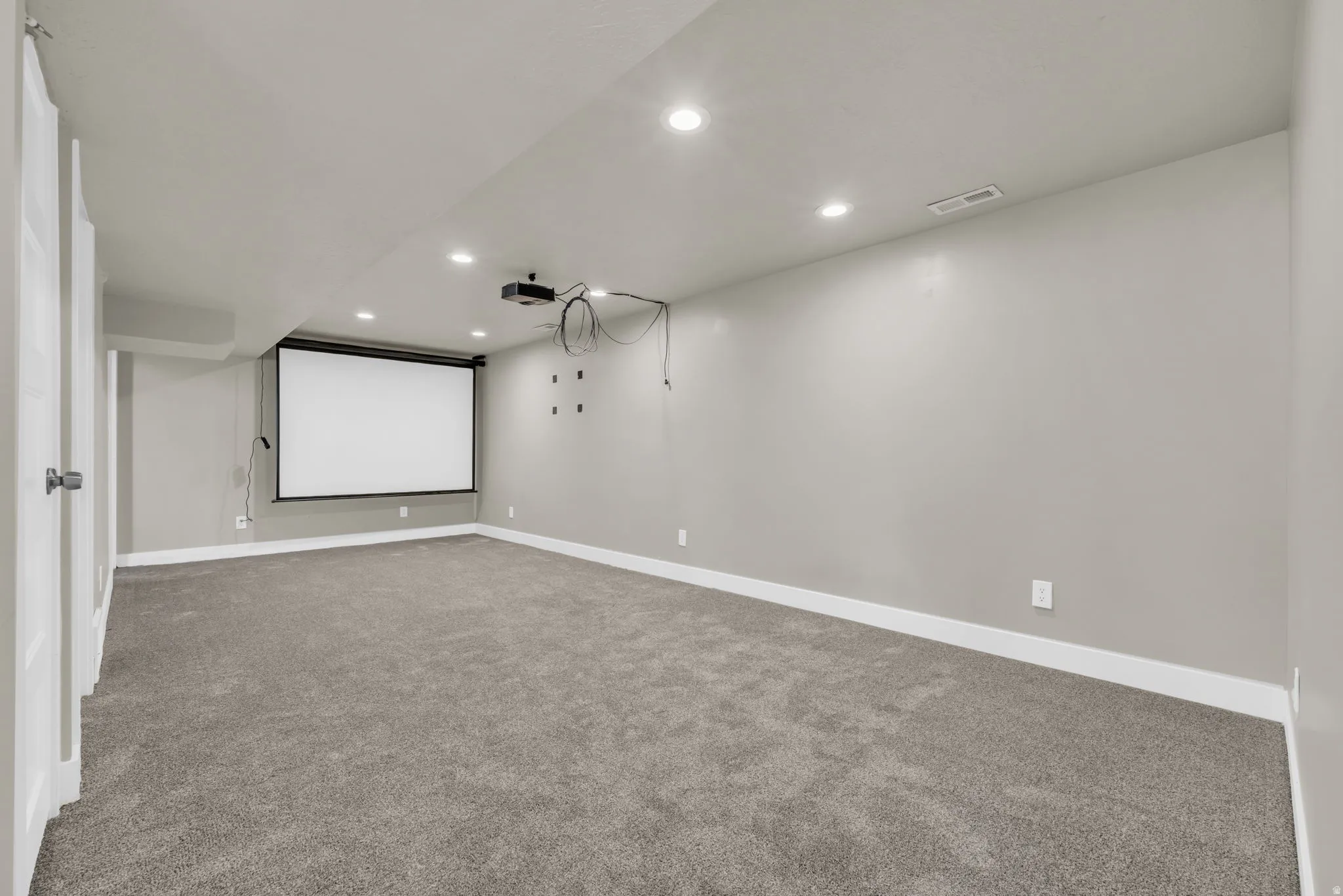Spacious room featuring a large retractable projector screen and overhead projector