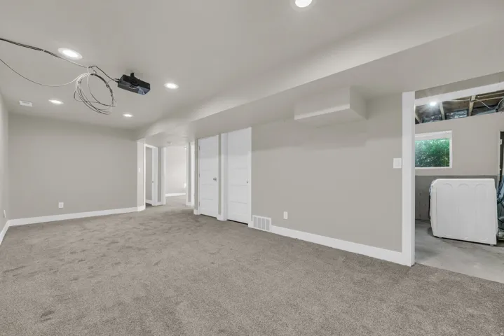 Finished basement space featuring recessed lighting and gray carpeting