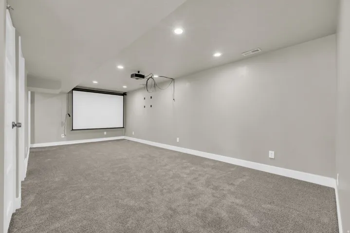Spacious room featuring a large retractable projector screen and overhead projector