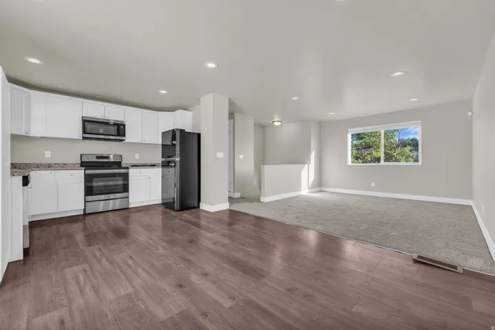 Open-concept living space with wood-finish flooring extending into the kitchen