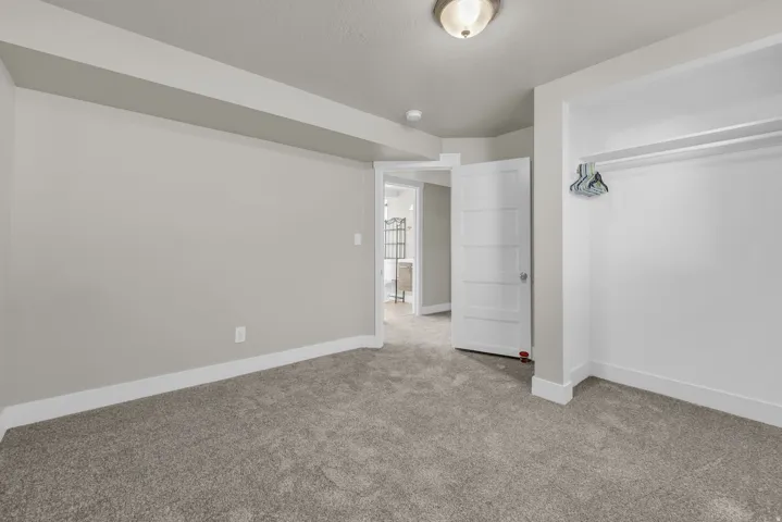 Carpeted room with light grey walls and white baseboards