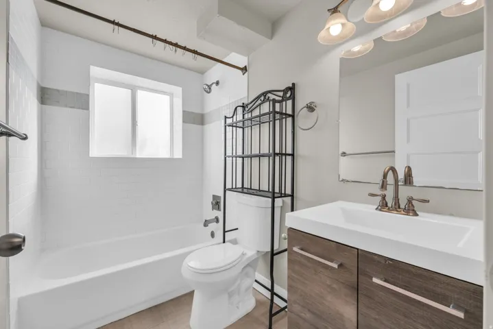 White subway tile tub surround with a light gray accent band