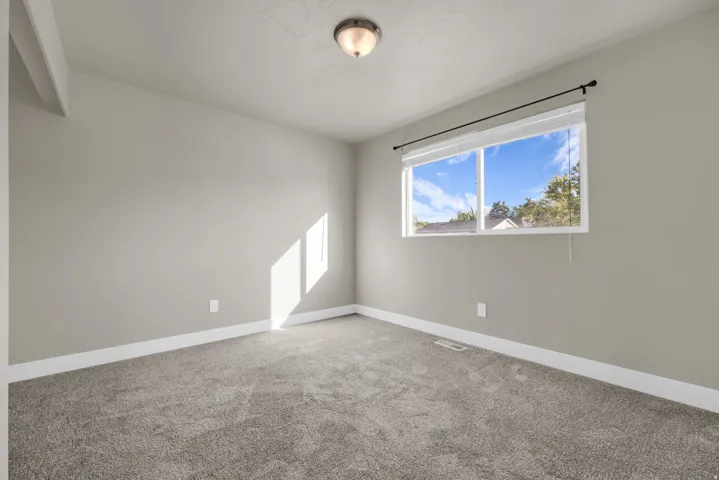 Neutral-toned walls complement the gray carpeting