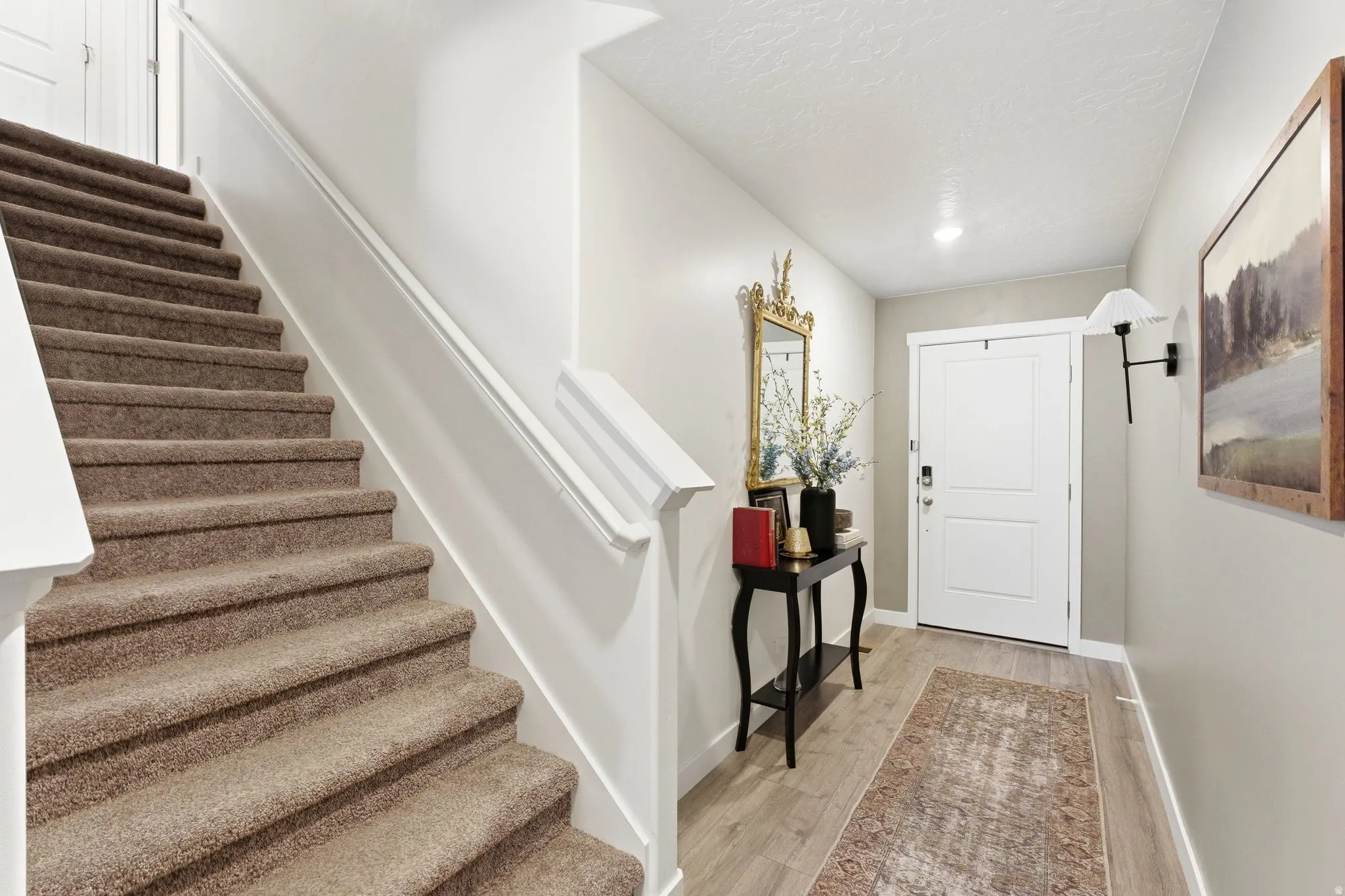 Entryway featuring wood-finish flooring, a white paneled entry door, recessed lighting, and a wall-mounted sconce