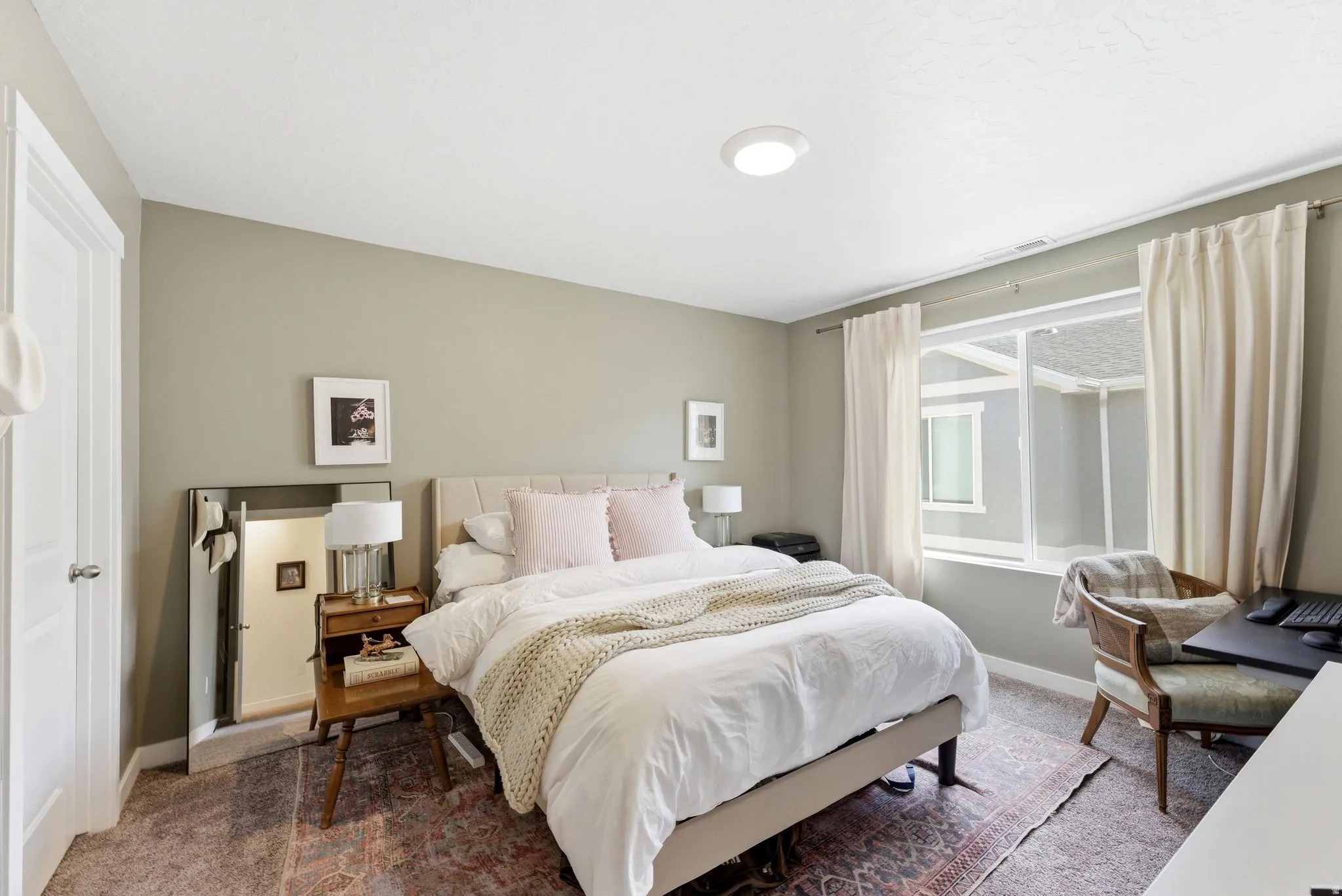 Bedroom featuring neutral-toned walls, recessed lighting, and a large window with white trim