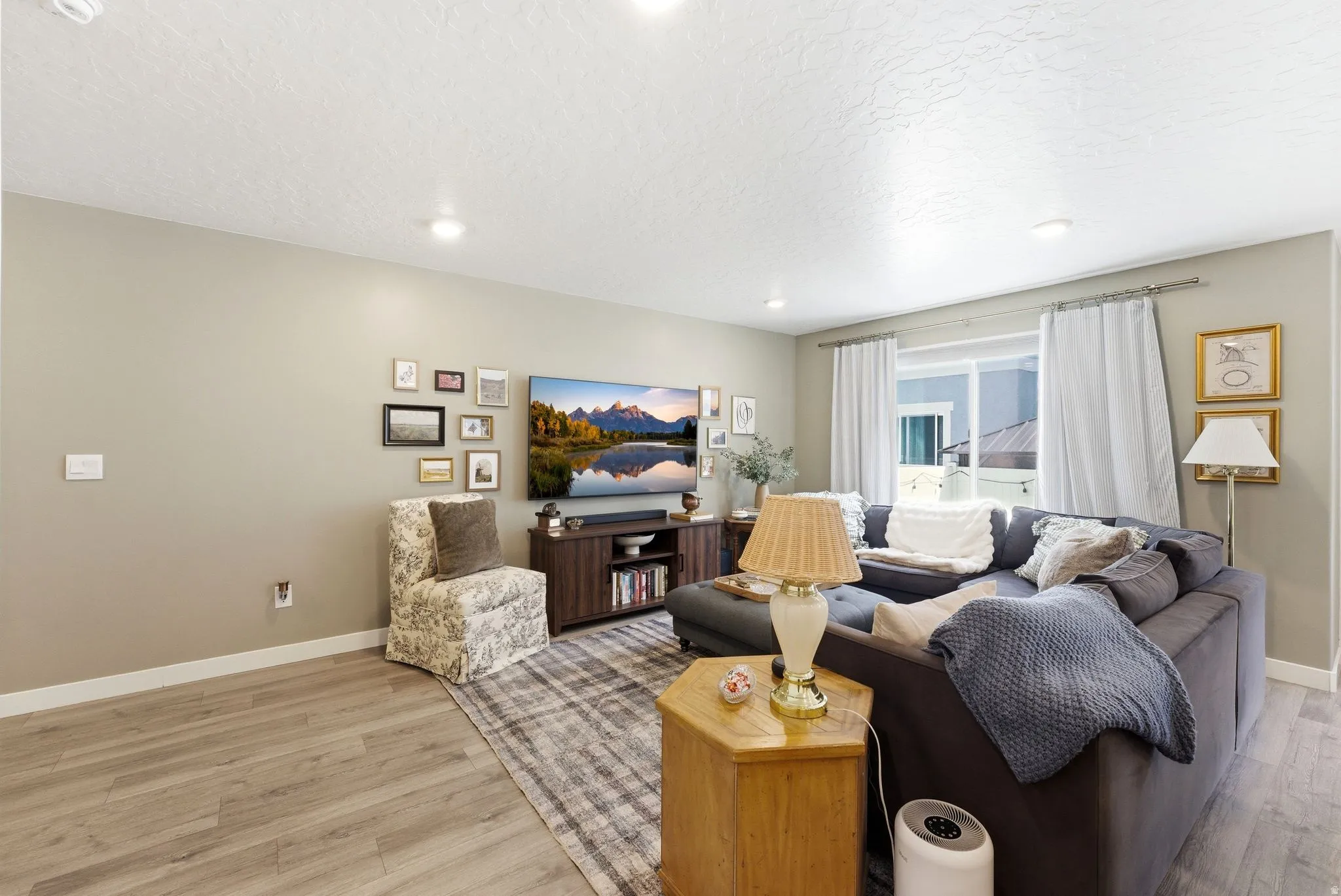 Spacious living area featuring light wood-finish flooring, recessed lighting, and neutral wall tones