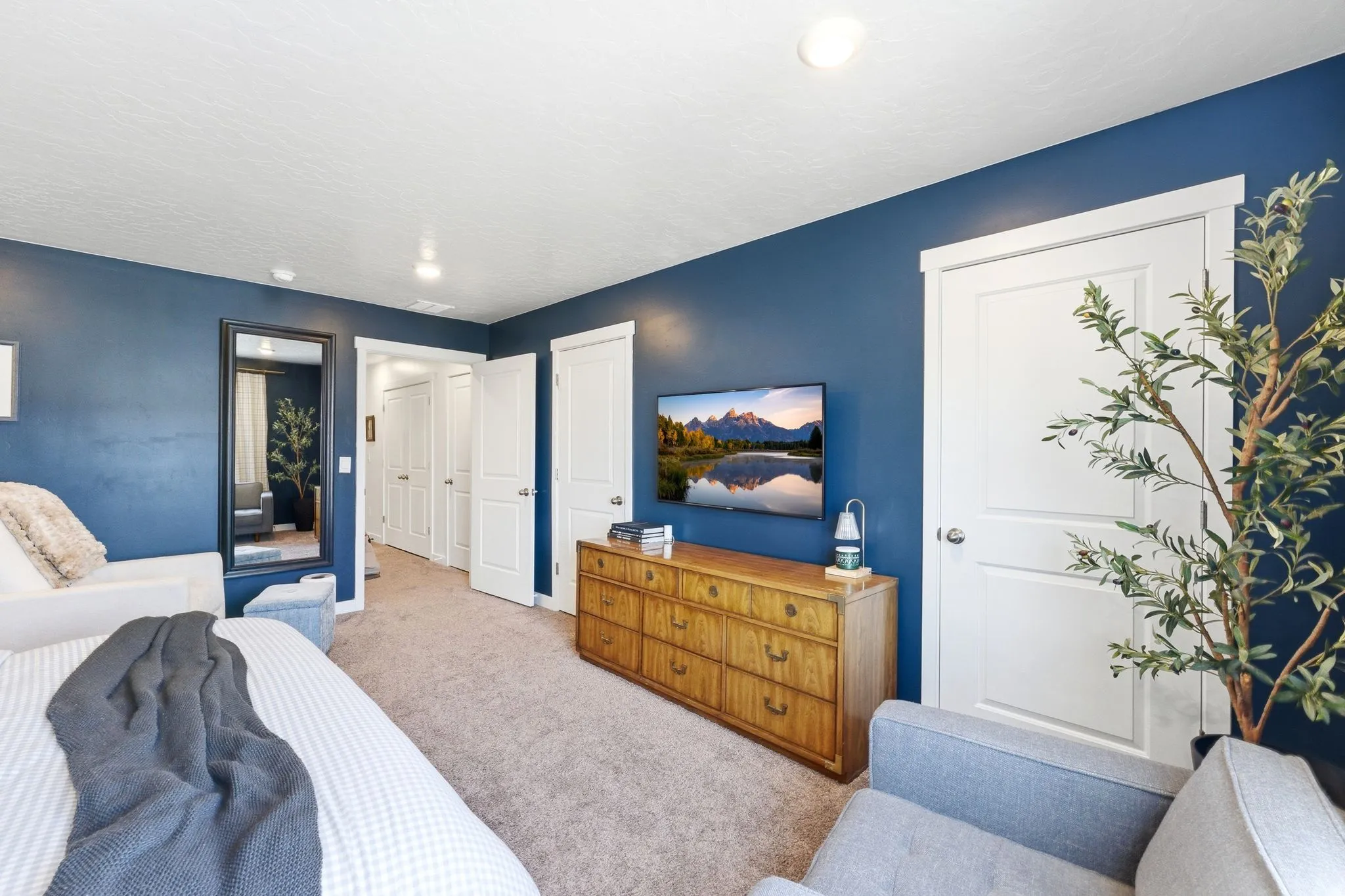 Carpeted room featuring a ceiling-mounted light fixture, recessed lighting, and a wall-mounted full-length mirror