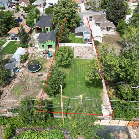 Expansive lot featuring a large grassy area, mature trees, and a detached garage