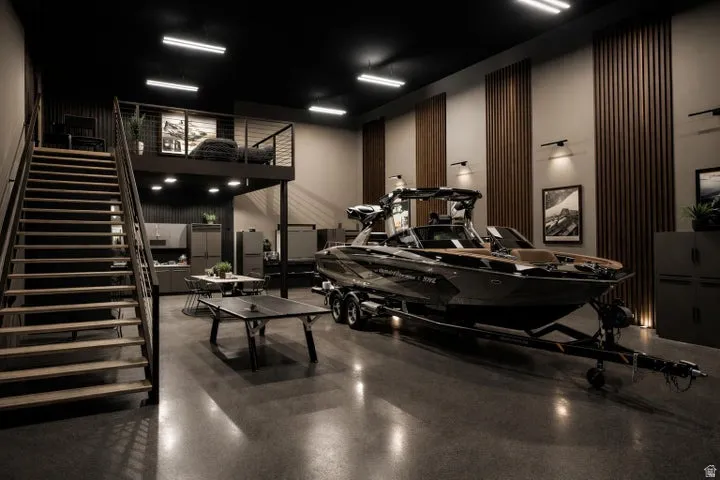 Spacious interior featuring a polished concrete floor, a full-height wood-finish slatted accent wall, and a metal staircase leading to an upper-level mezzanine