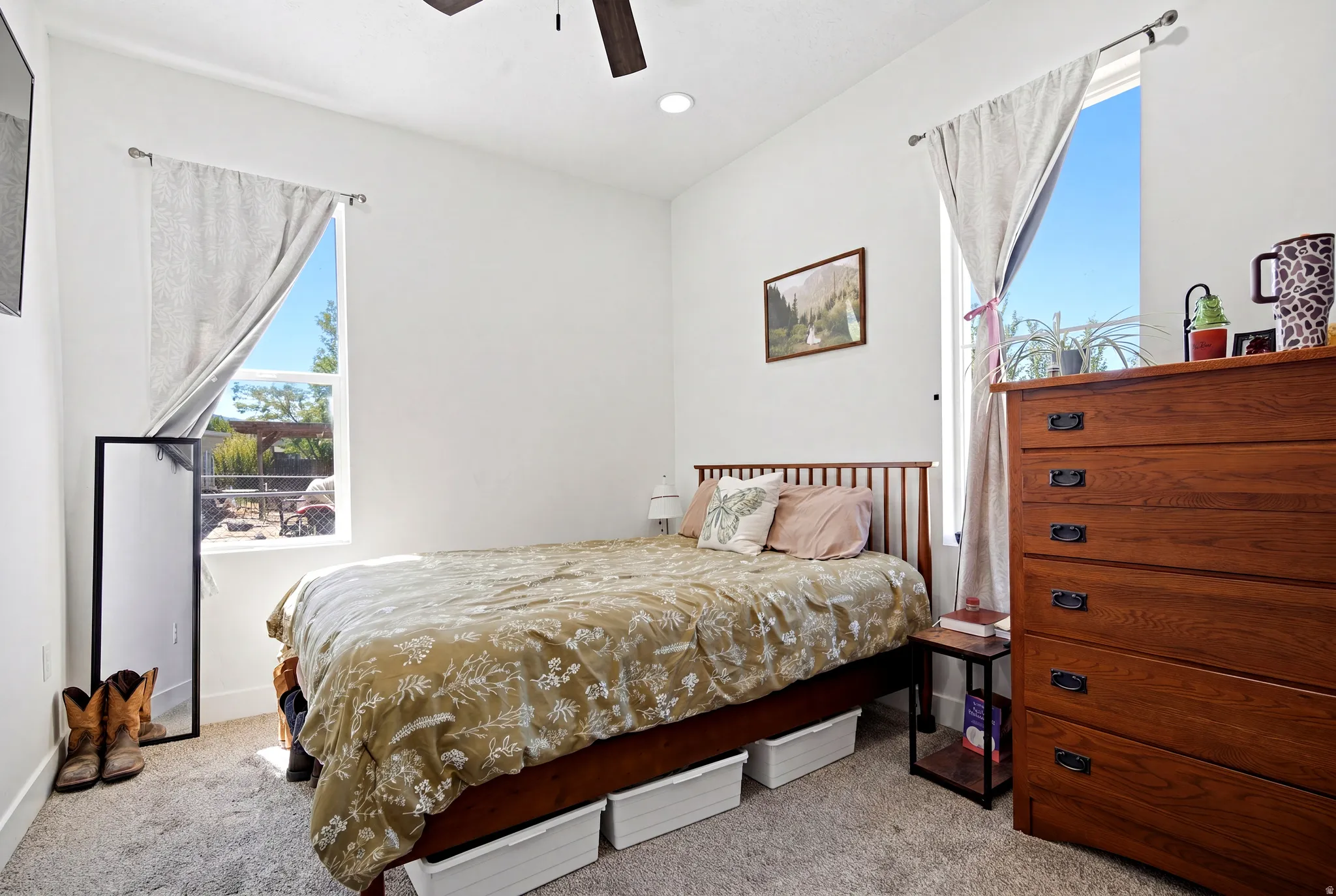 Carpeted interior space featuring white walls and two large windows