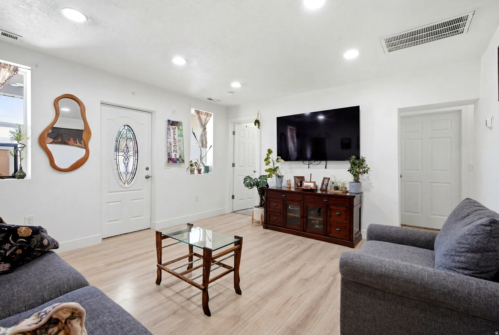 Living area featuring wood-finish flooring, recessed lighting, and white paneled doors