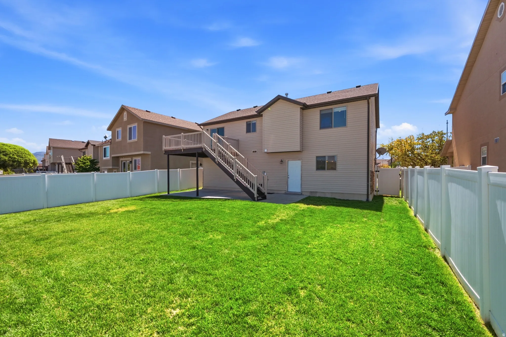 Expansive green lawn enclosed by white vinyl fencing