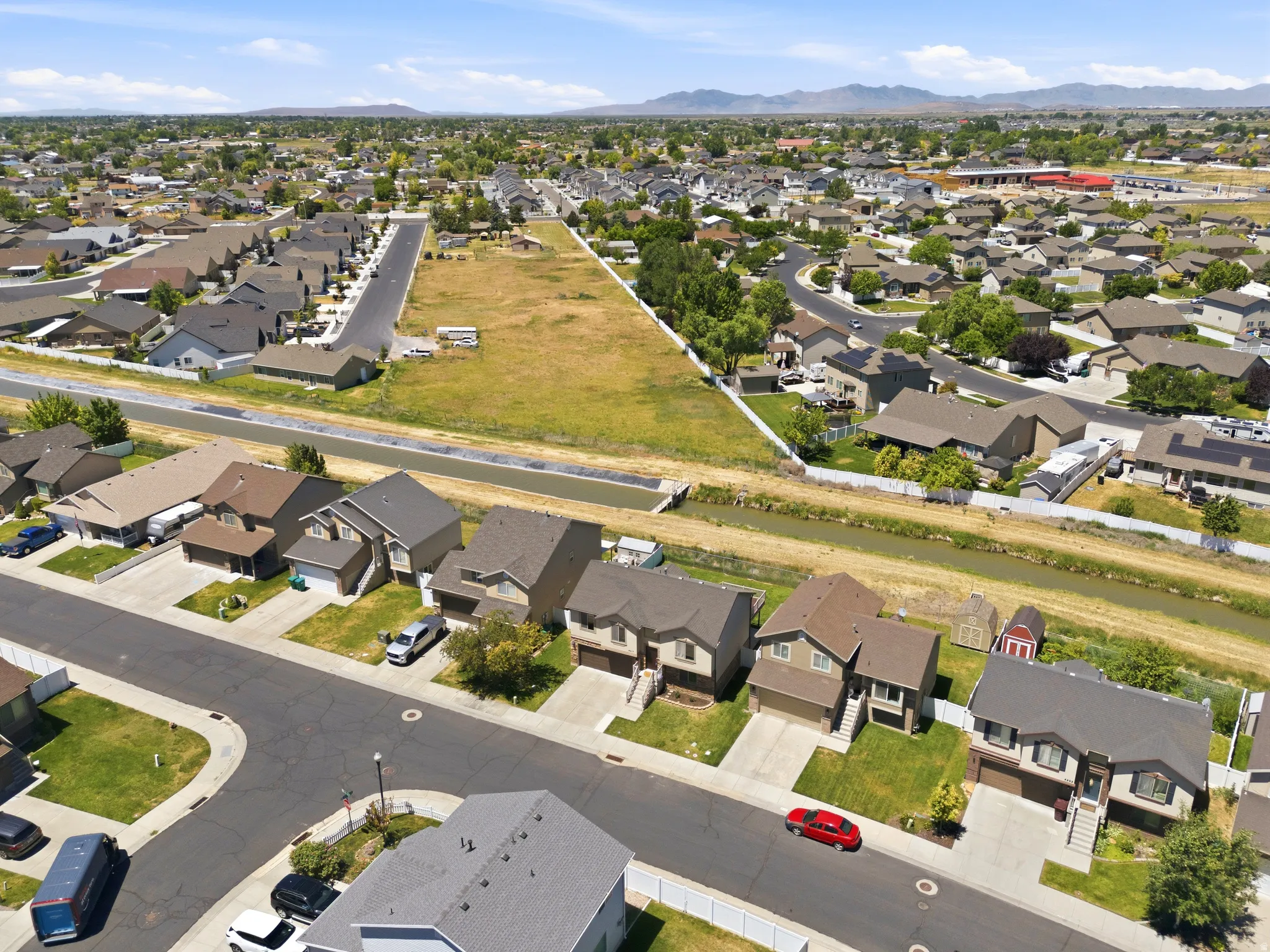 Aerial overview of a residential neighborhood with single-family homes and mountain backdrops