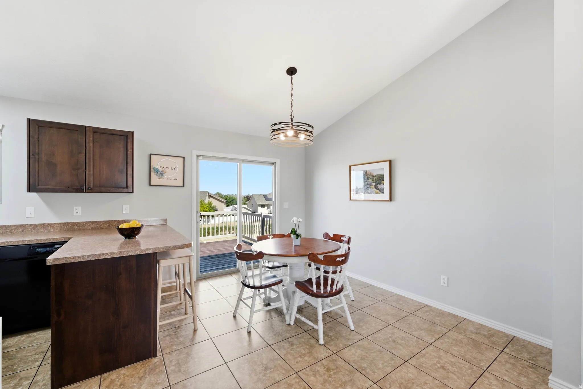 Kitchen and dining area featuring tile flooring, dark wood cabinetry, and a light-toned countertop