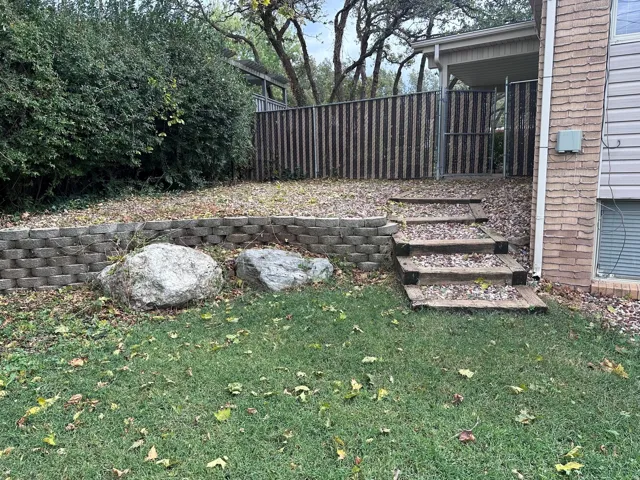 Tiered backyard with a retaining wall and natural stone accents