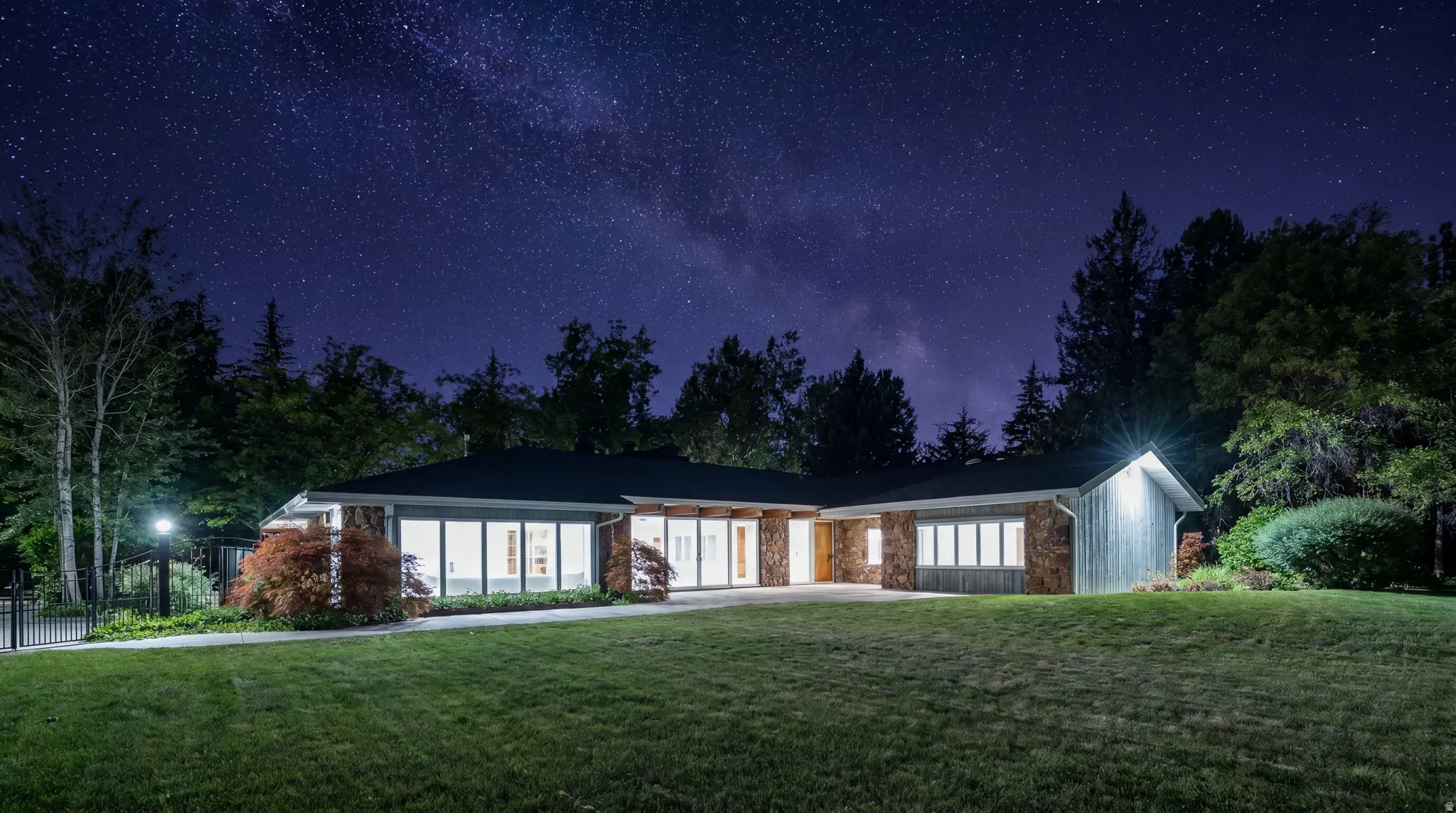 Single-story residence featuring a dark-pitched roofline and a stone facade