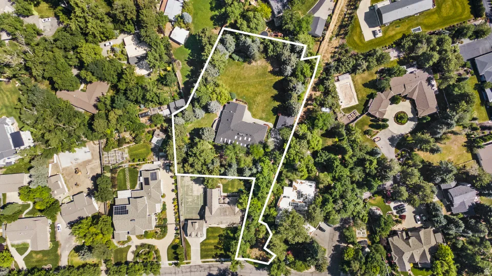 Expansive property featuring mature trees and established landscaping