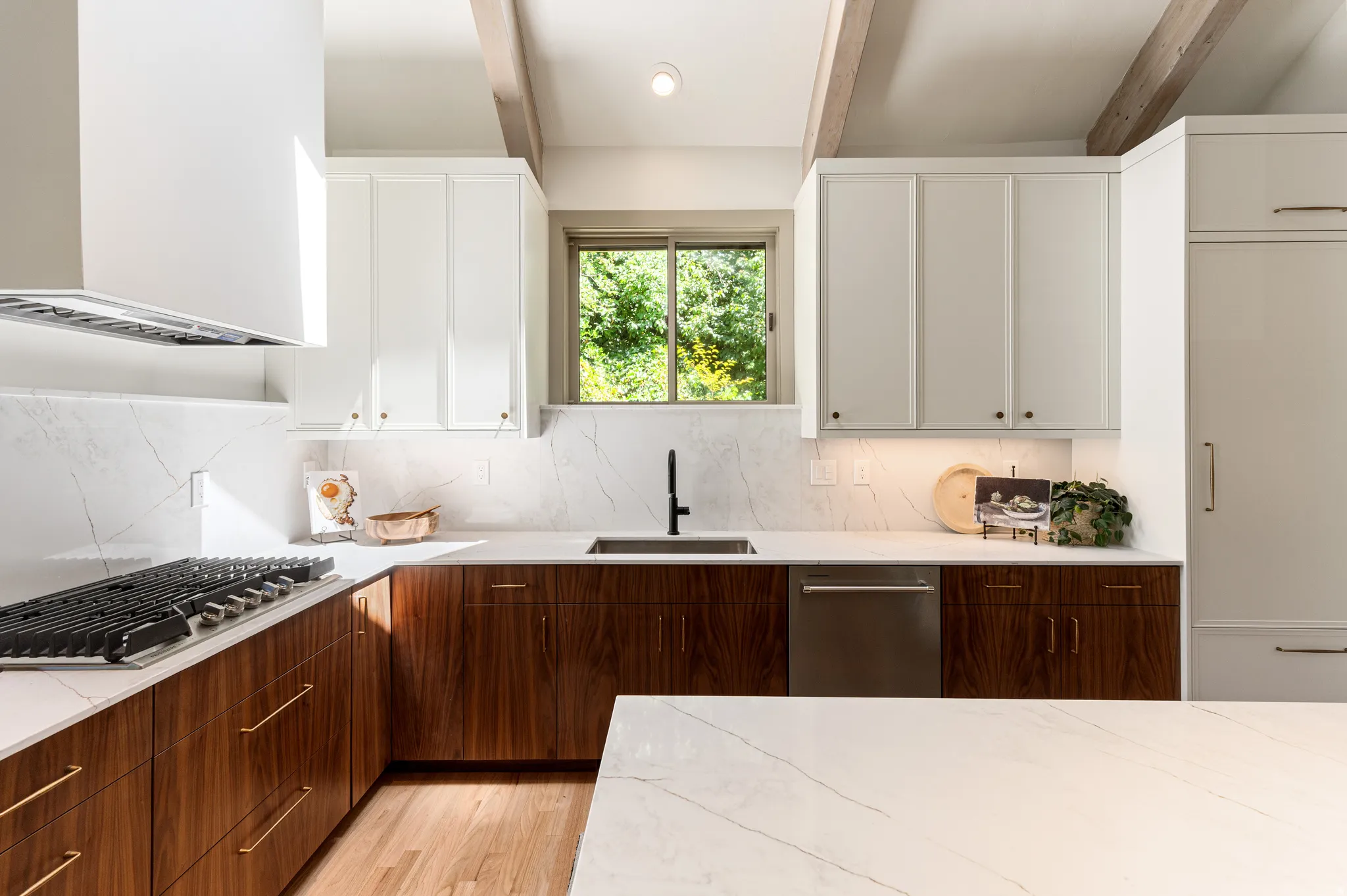 Kitchen featuring wood-finish lower cabinetry, white upper cabinetry, and white countertops