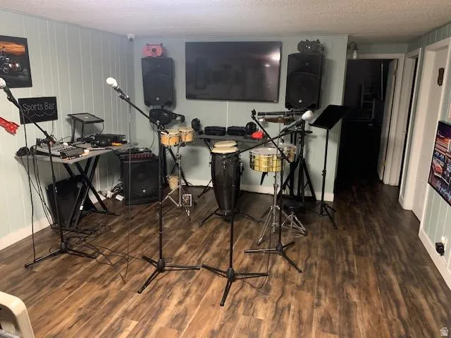 Entertainment space featuring wood-finish flooring, light blue vertical paneling, and recessed lighting