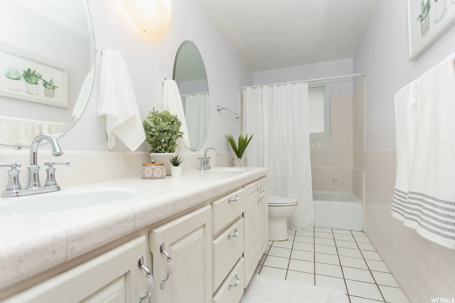Double vanity with integrated sinks, chrome faucets, and an oval mirror