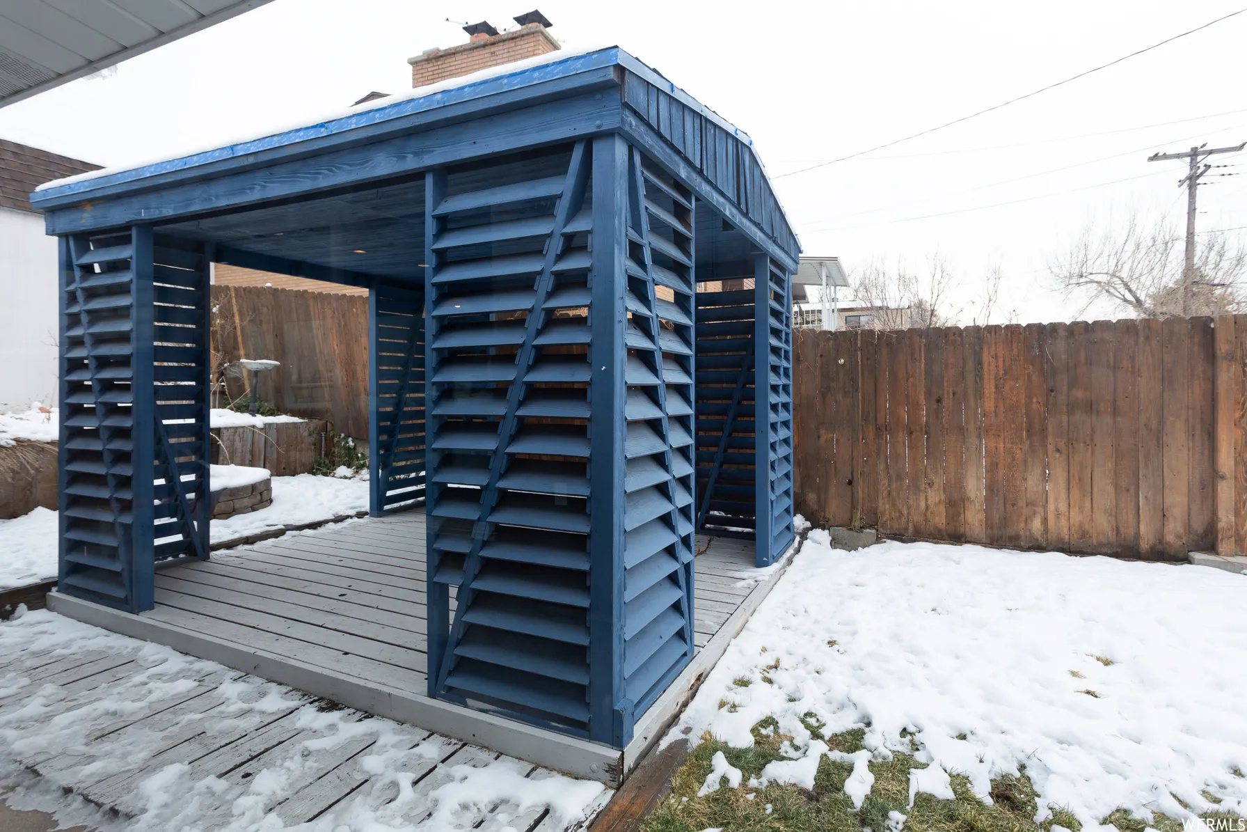 Freestanding blue slatted gazebo with a wood-finish floor