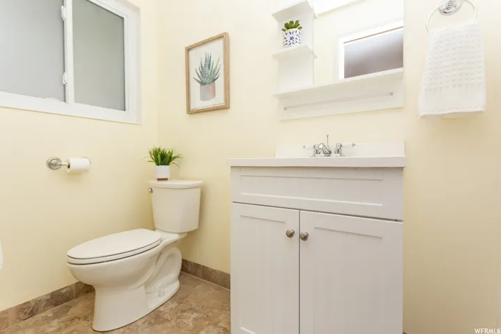 en suite bathroom. White vanity with brushed nickel hardware, a single basin sink, and a chrome faucet