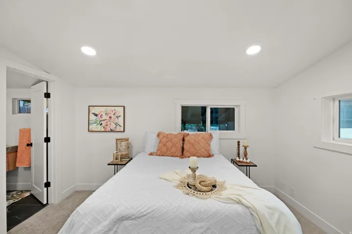 Bedroom with recessed lighting, carpeted flooring, and two windows with white trim