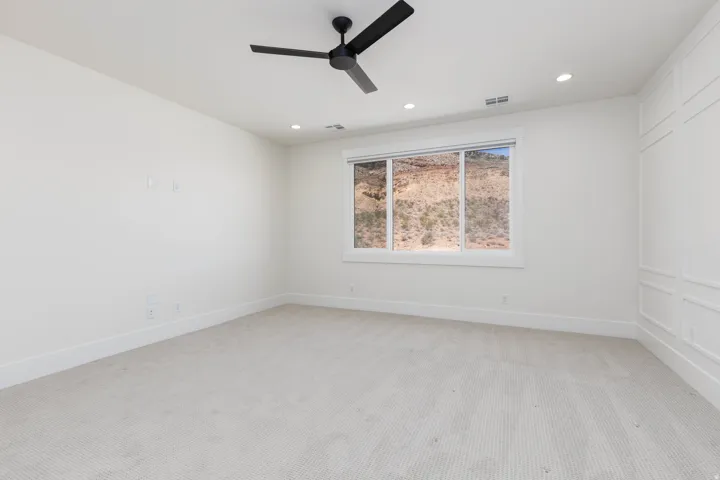 White painted walls, recessed lighting, and a black ceiling fan