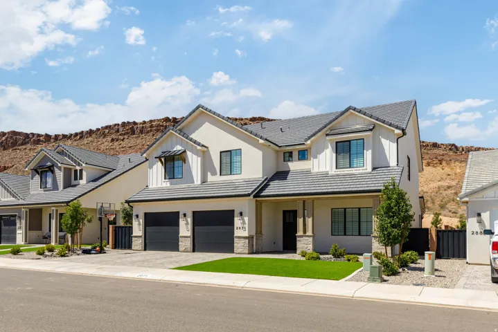 Contemporary exterior with stucco and vertical siding accents, two-car garage with dark doors, low-maintenance landscaping, and a covered entry