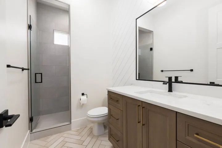 Glass-enclosed shower with tiled walls and a transom window